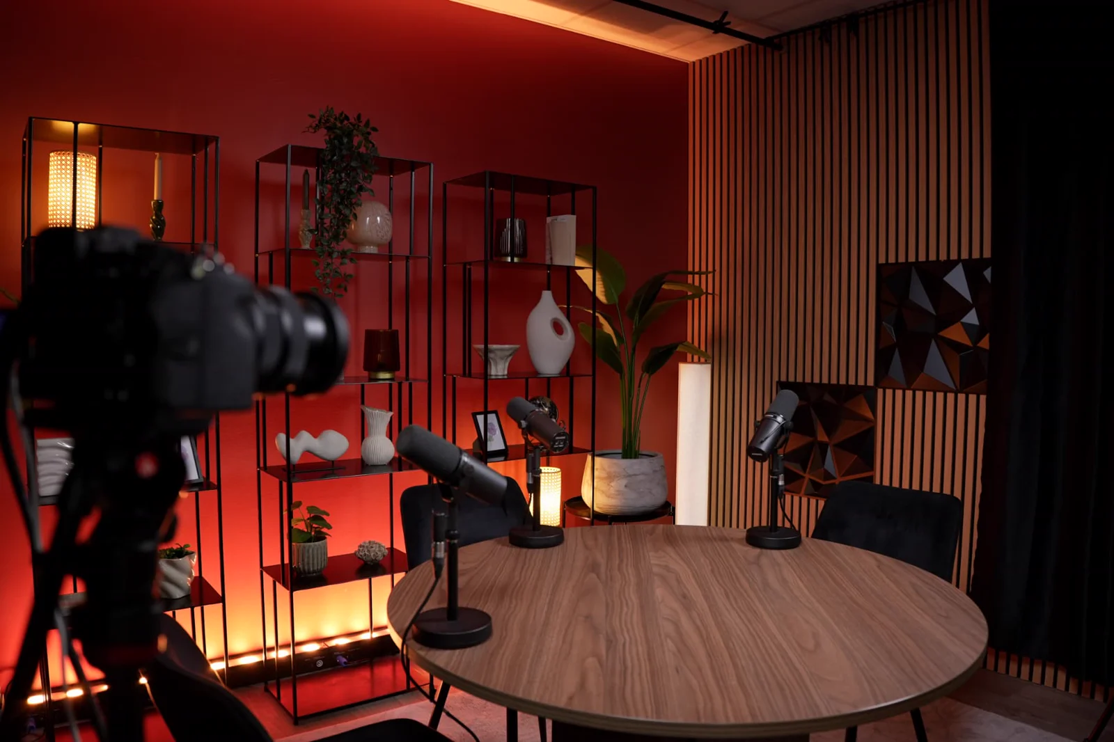 Vue d’ensemble du Studio Perspective avec table, microphones et décor rouge